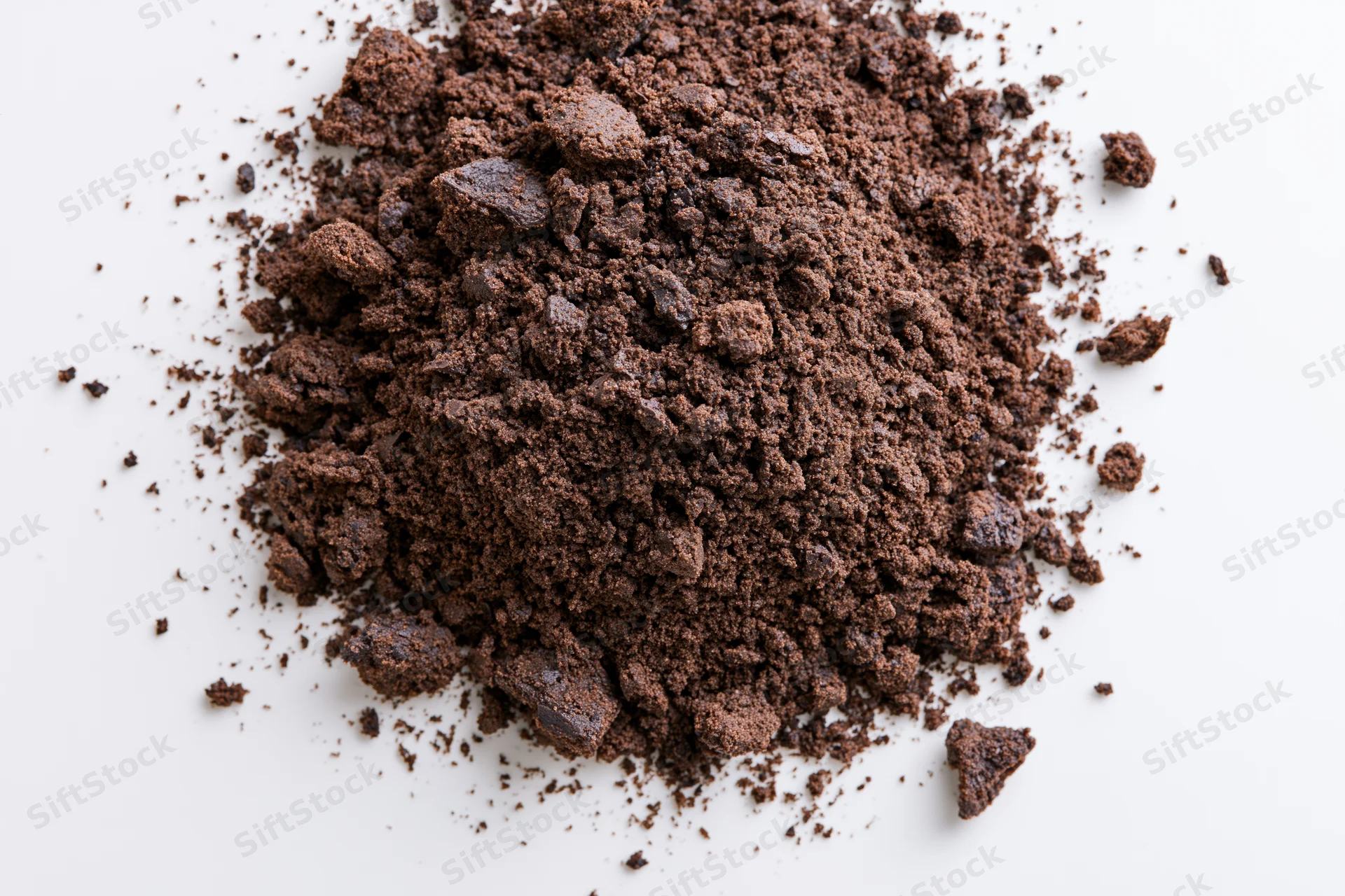 Pile of chocolate cake crumbs scattered on white surface