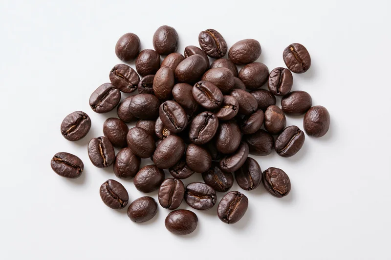Dark roasted coffee beans scattered loosely around a center