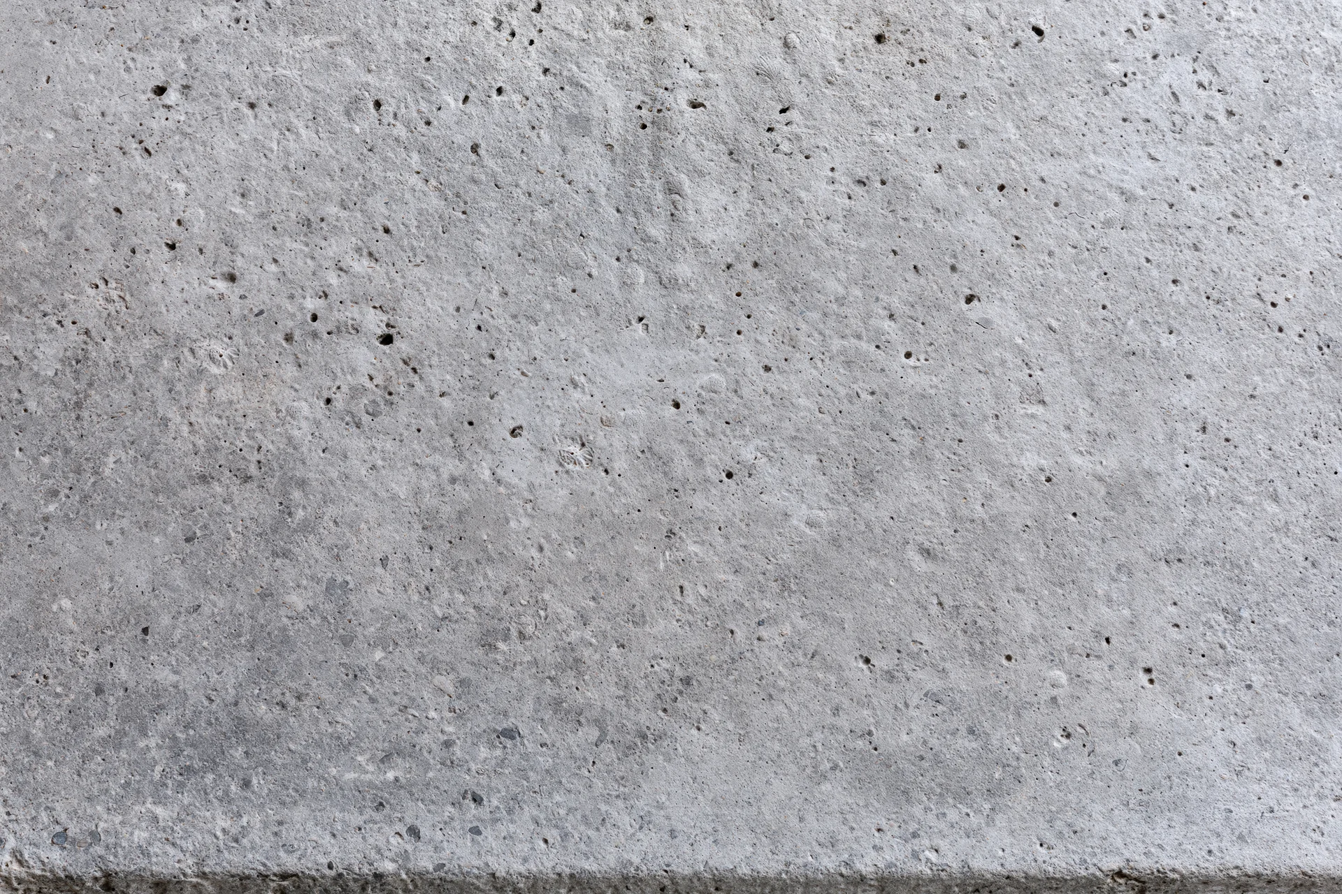 Flat concrete surface filling the frame with rough texture and small pits