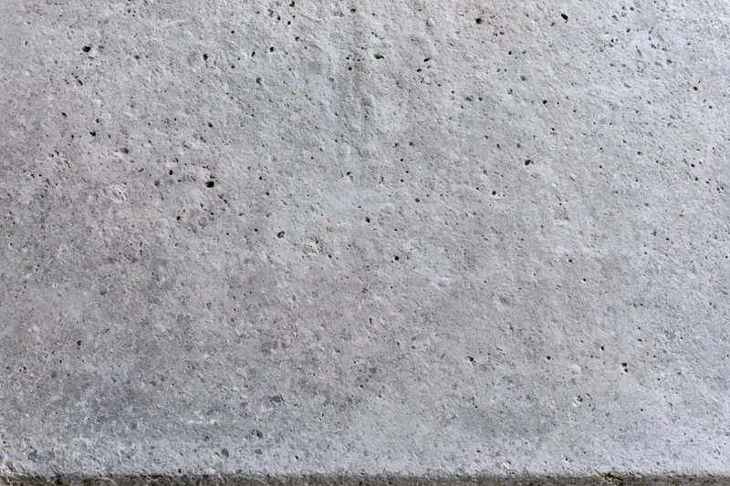 Flat concrete surface filling the frame with rough texture and small pits