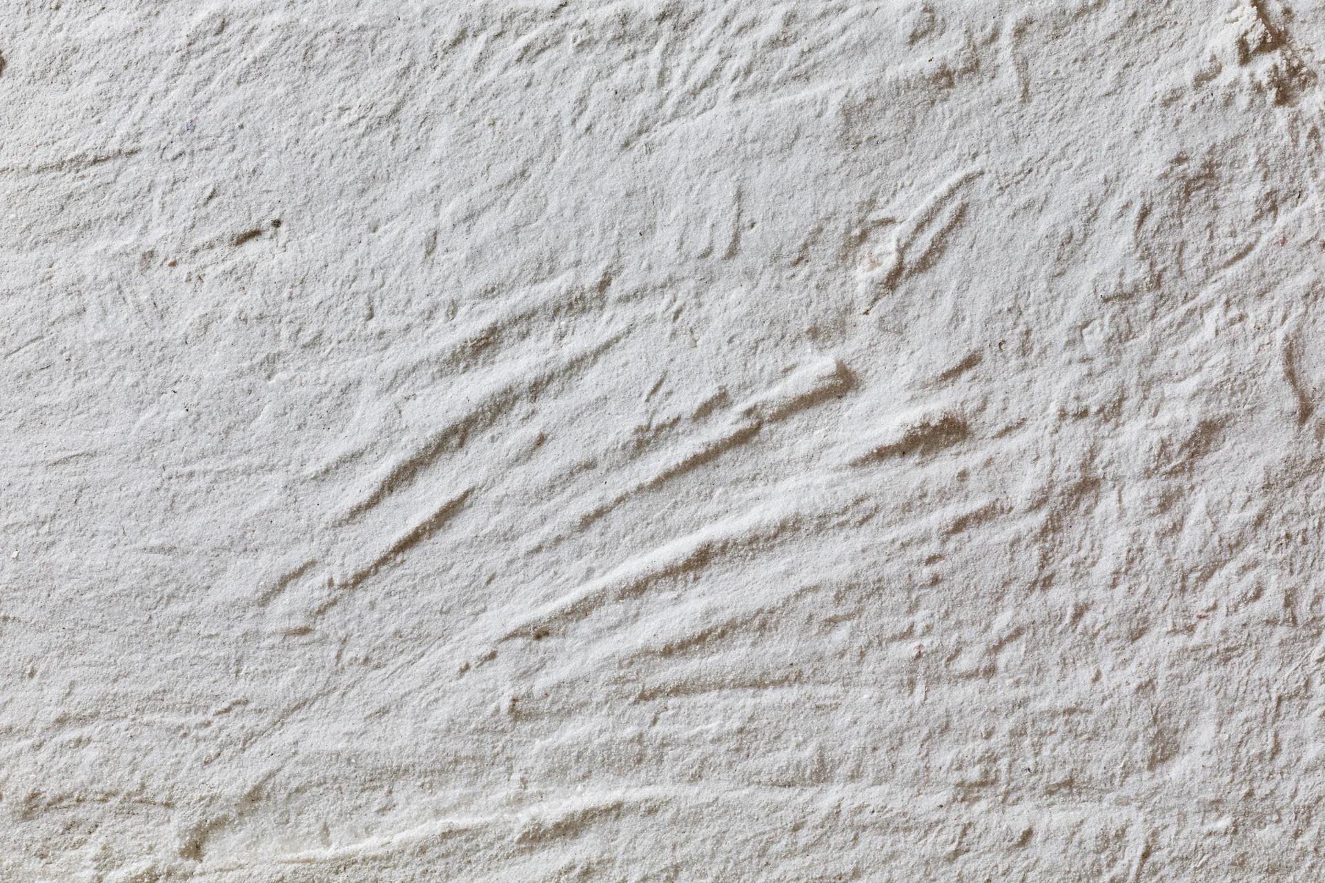 Close-up of a rough gray concrete wall surface with visible texture and imperfections