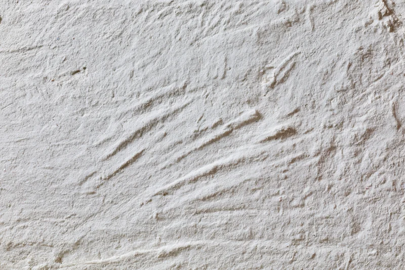 Close-up of a rough gray concrete wall surface with visible texture and imperfections