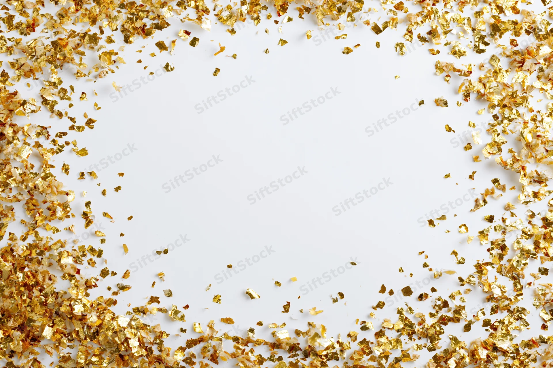 Gold metallic confetti scattered in a frame around a white background with copyspace