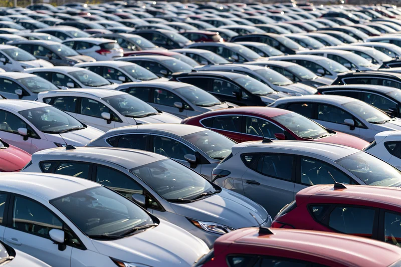 Rows of new cars parked tightly in an outdoor dealership lot