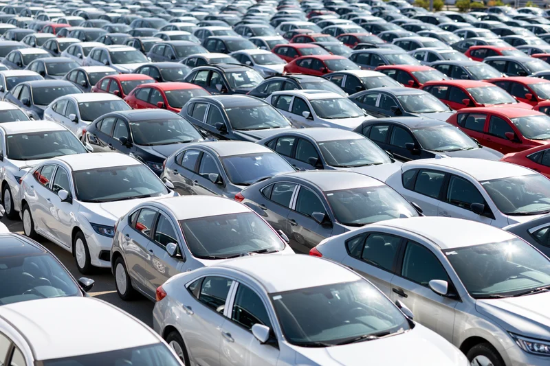 Rows of new cars parked tightly in an outdoor dealership lot