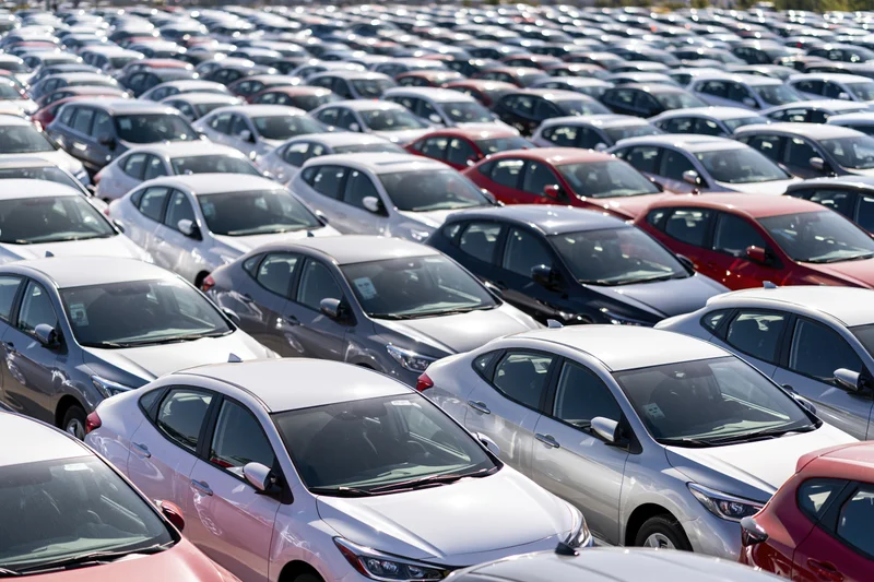 Rows of new cars parked tightly in an outdoor dealership lot