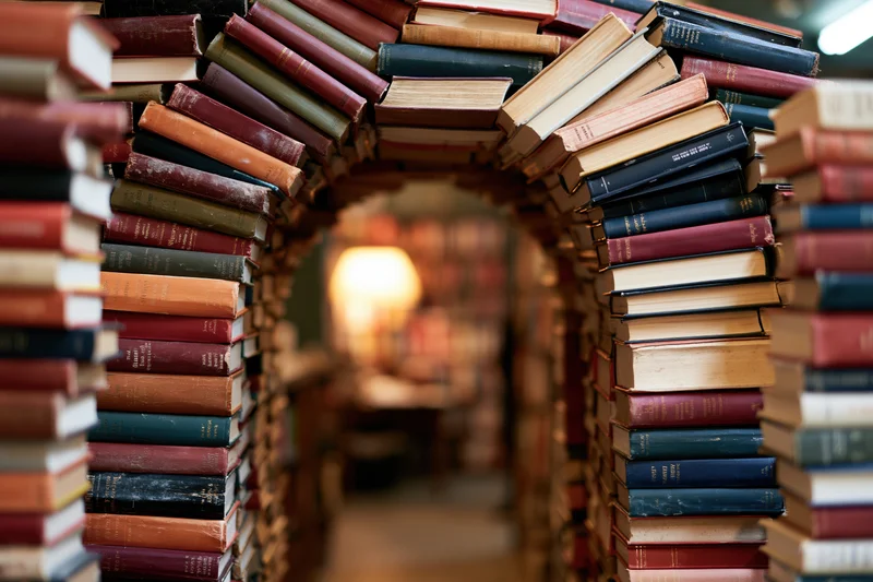 Books stacked to form a tunnel archway in a library interior