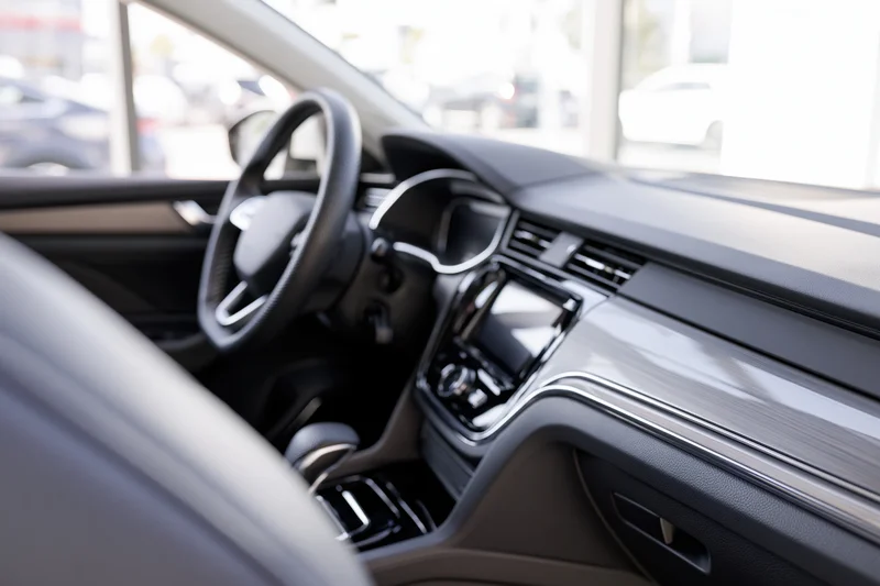 Luxury sedan interior viewed from passenger side showing dashboard and steering wheel