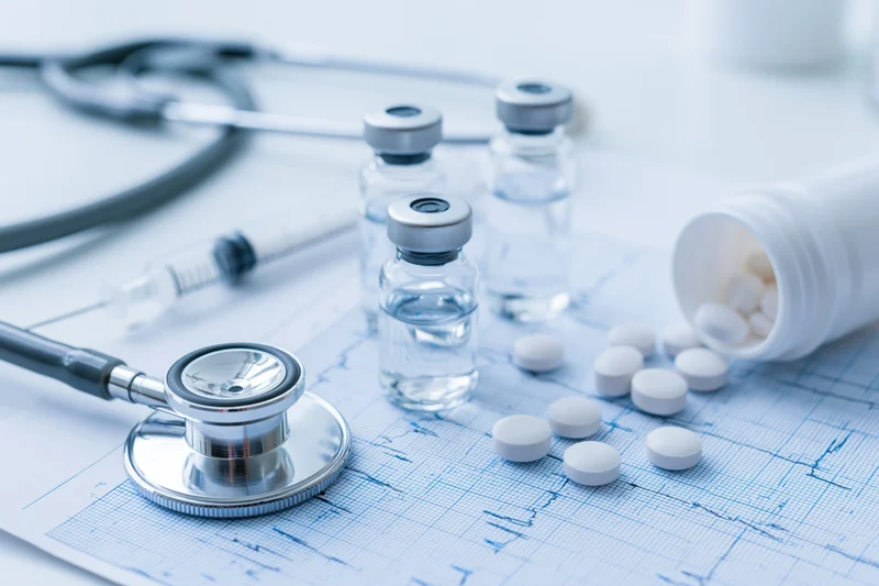 Stethoscope and medical supplies arranged on an electrocardiogram chart