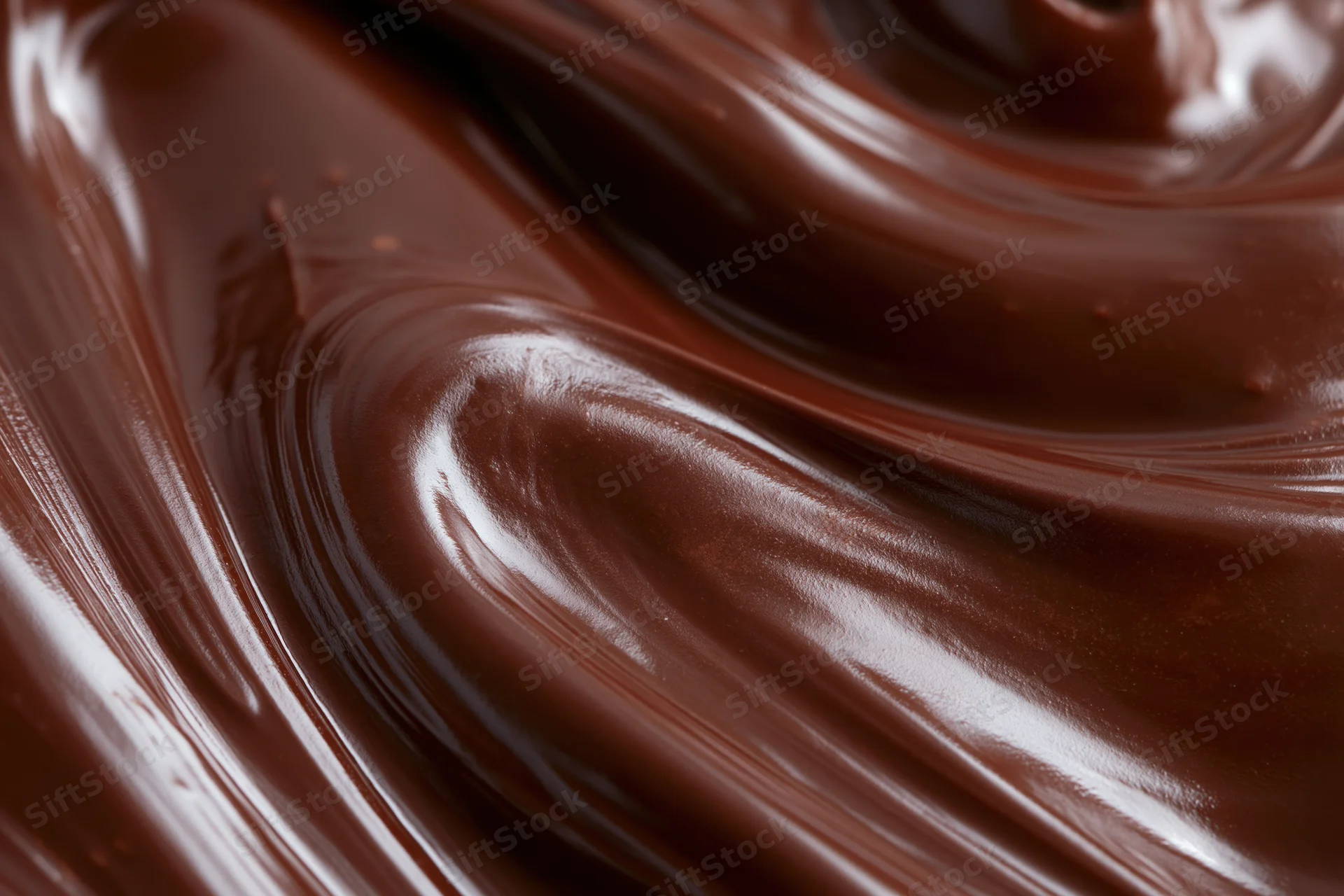 Melted dark chocolate swirling in smooth glossy waves filling the frame