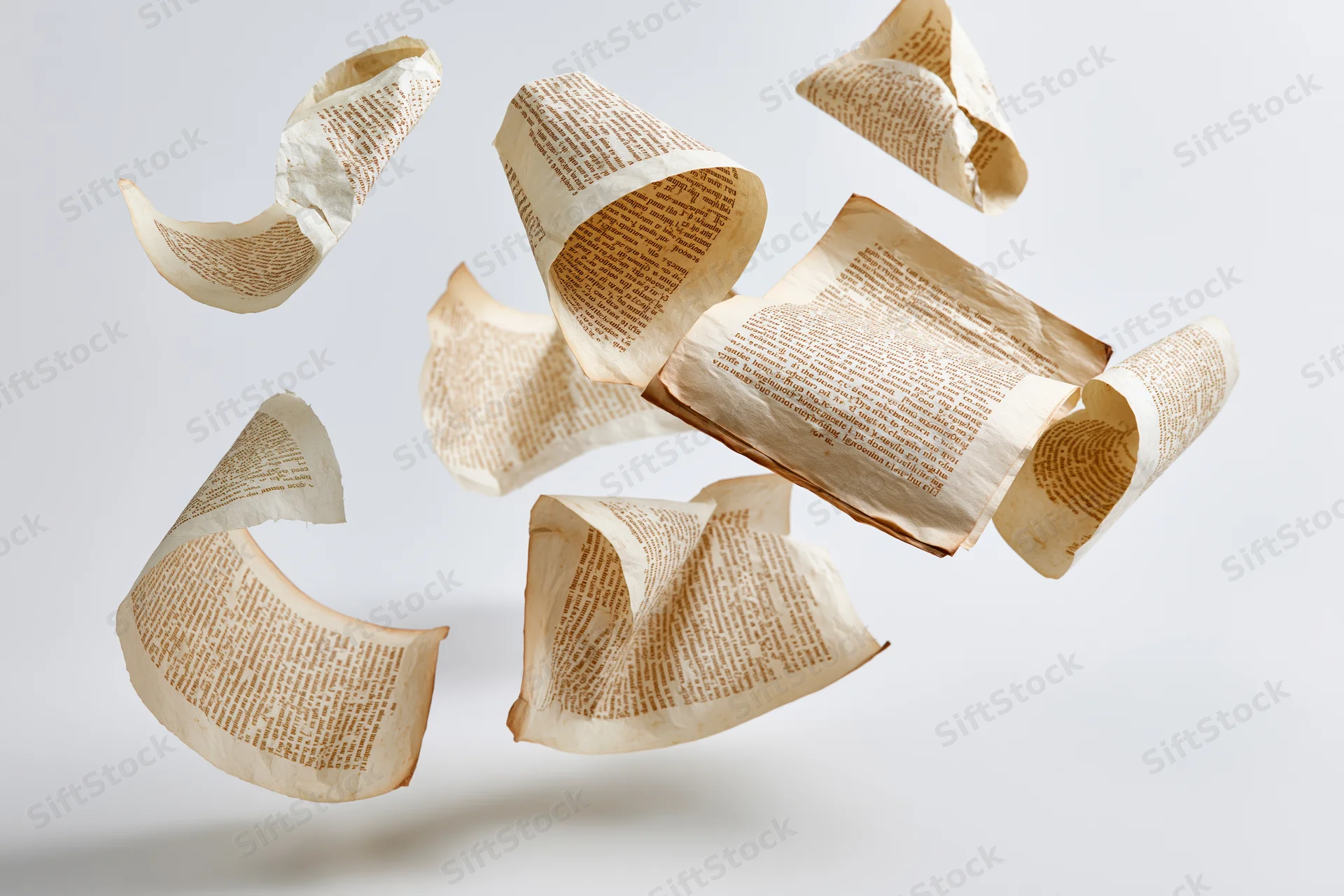 Aged paper pages with printed text tumbling in midair against a white background