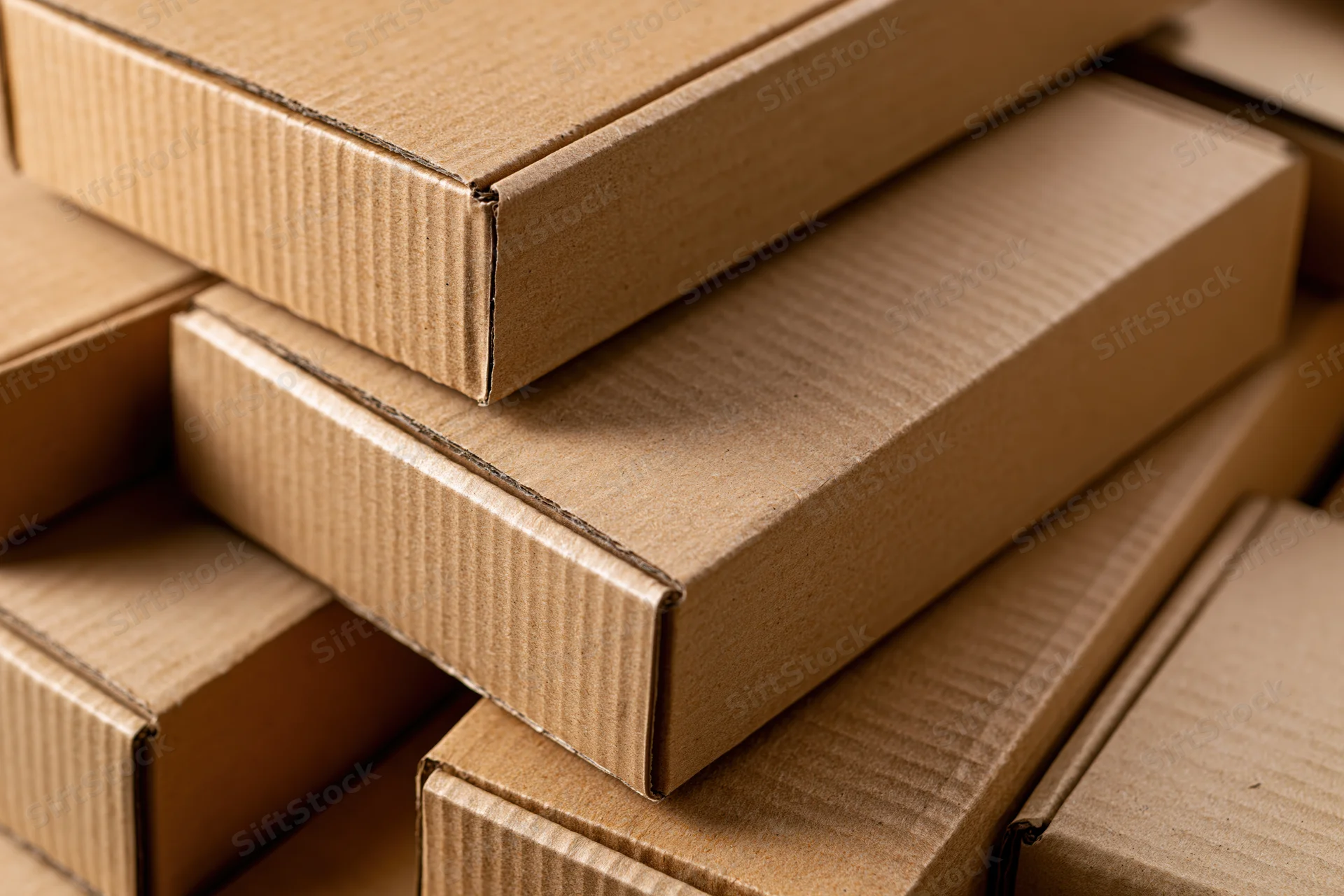 Stack of flat kraft cardboard boxes arranged closely together
