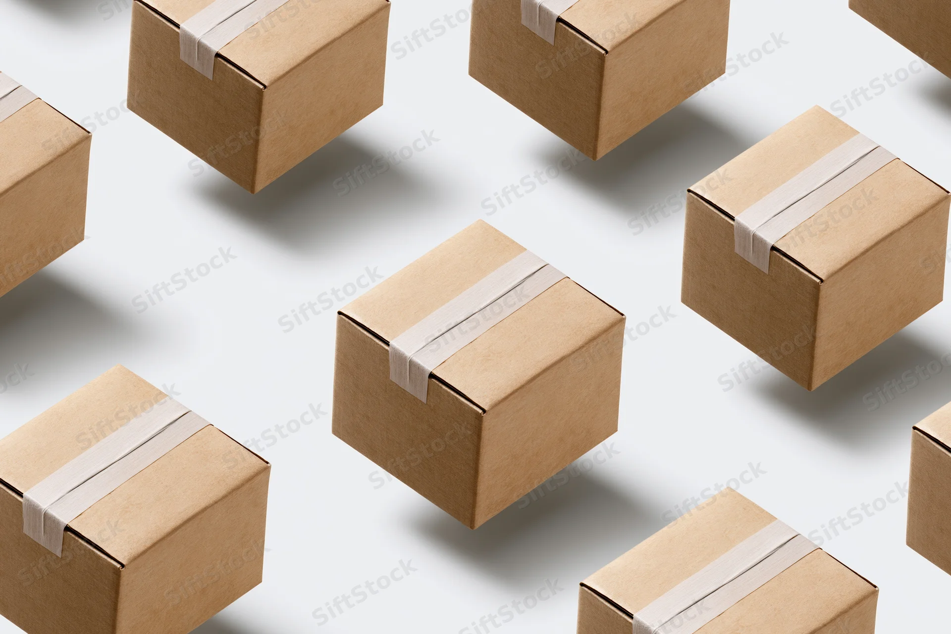 Multiple identical small cardboard shipping boxes arranged in a flat lay pattern on a white surface