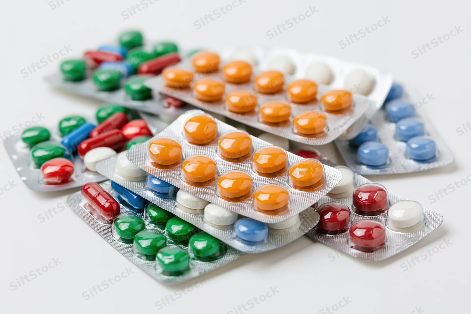 Multiple pharmaceutical blister packs scattered on a white surface