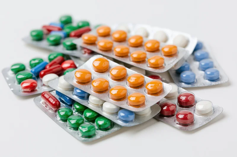 Multiple pharmaceutical blister packs scattered on a white surface