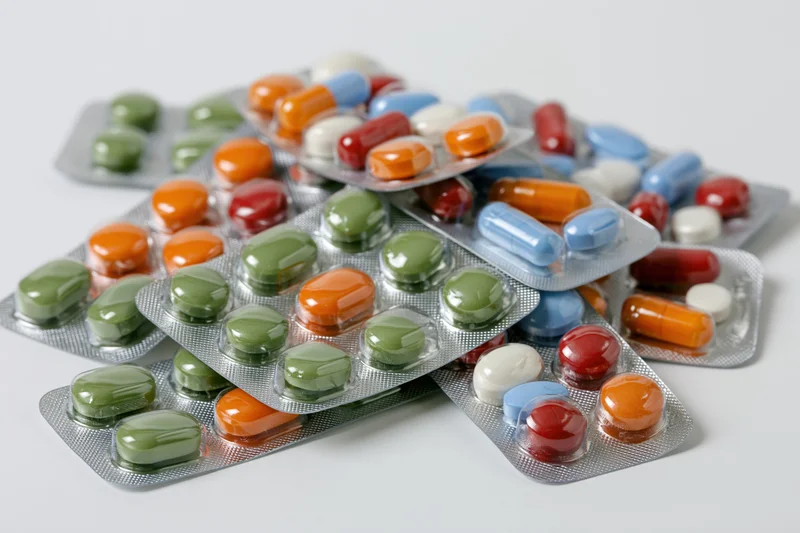 Multiple pharmaceutical blister packs scattered on a white surface
