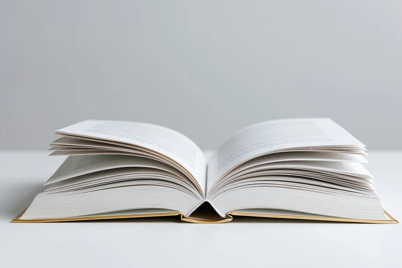 Open hardcover book with gold spine lying flat on white surface pages spread