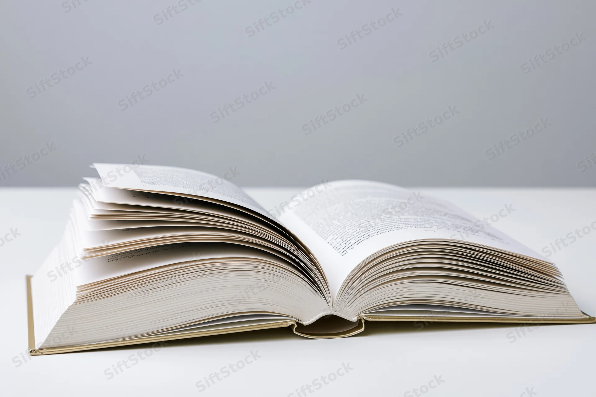 Open hardcover book lying flat with pages spread on white surface