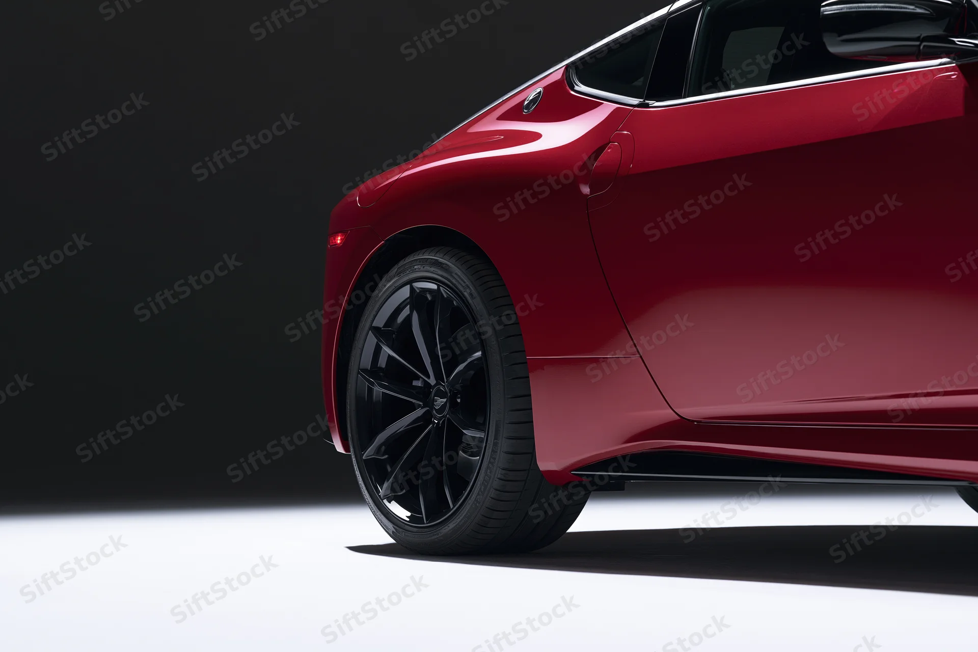 Red electric sports car side profile from low rear threequarter angle in studio lighting