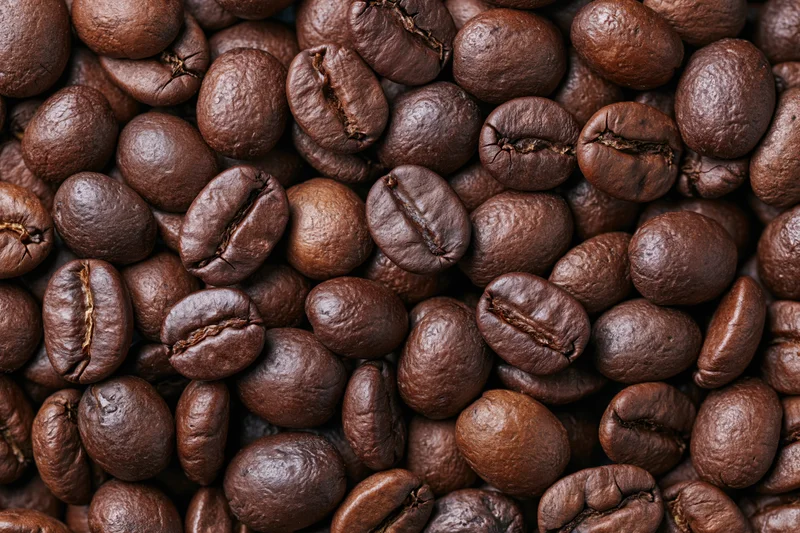Roasted coffee beans filling the frame in a closeup texture shot