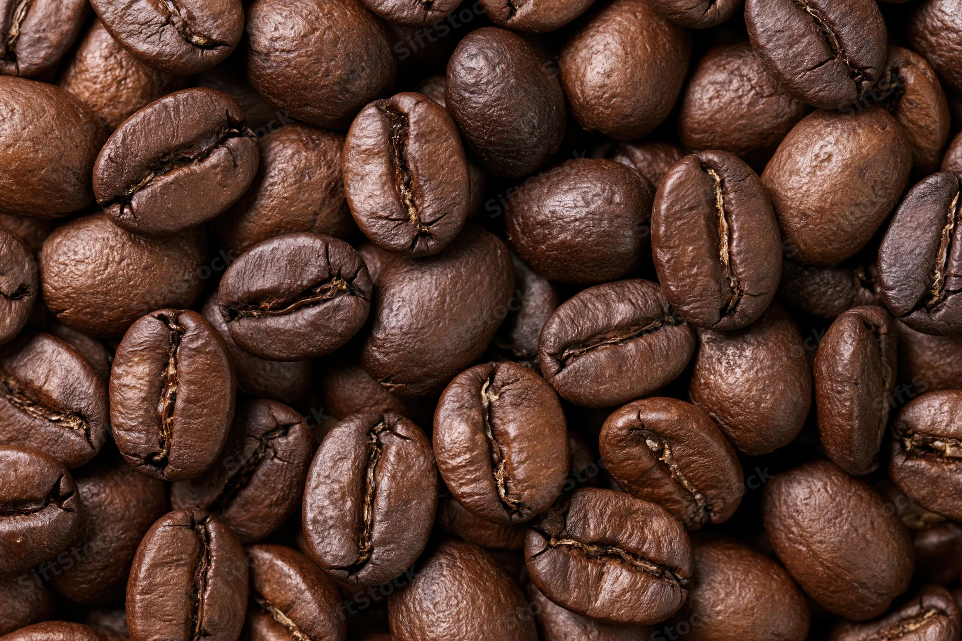Roasted coffee beans filling the frame in a closeup texture view