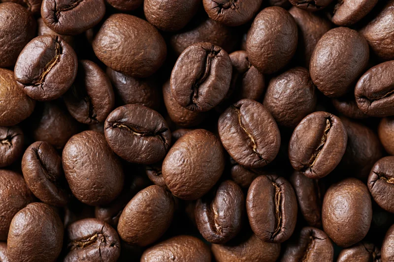 Roasted coffee beans filling the frame in a closeup view