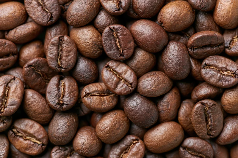 Roasted coffee beans filling the frame in a closeup view