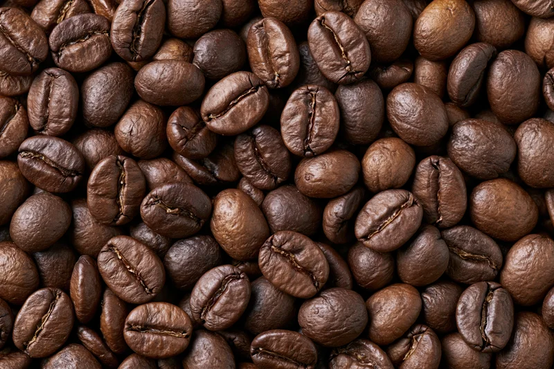 Roasted coffee beans filling the frame in a closeup texture view
