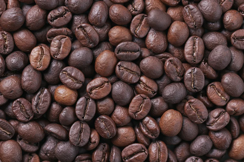 Roasted coffee beans filling the frame in an overhead flat lay view