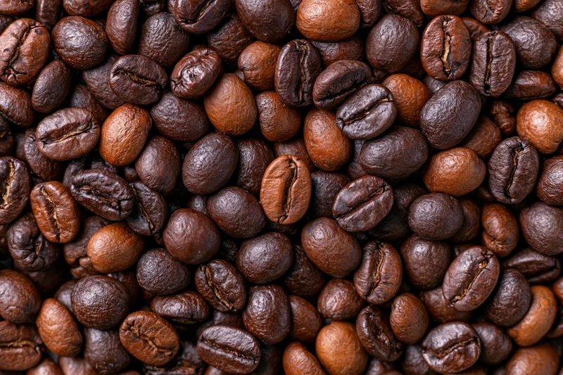Roasted coffee beans filling the frame in an overhead flat lay view