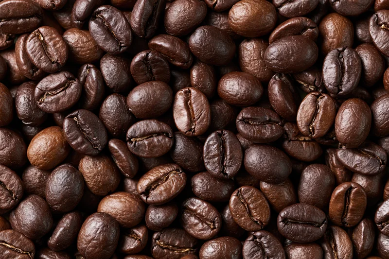 Roasted coffee beans filling the frame in an overhead flat lay view