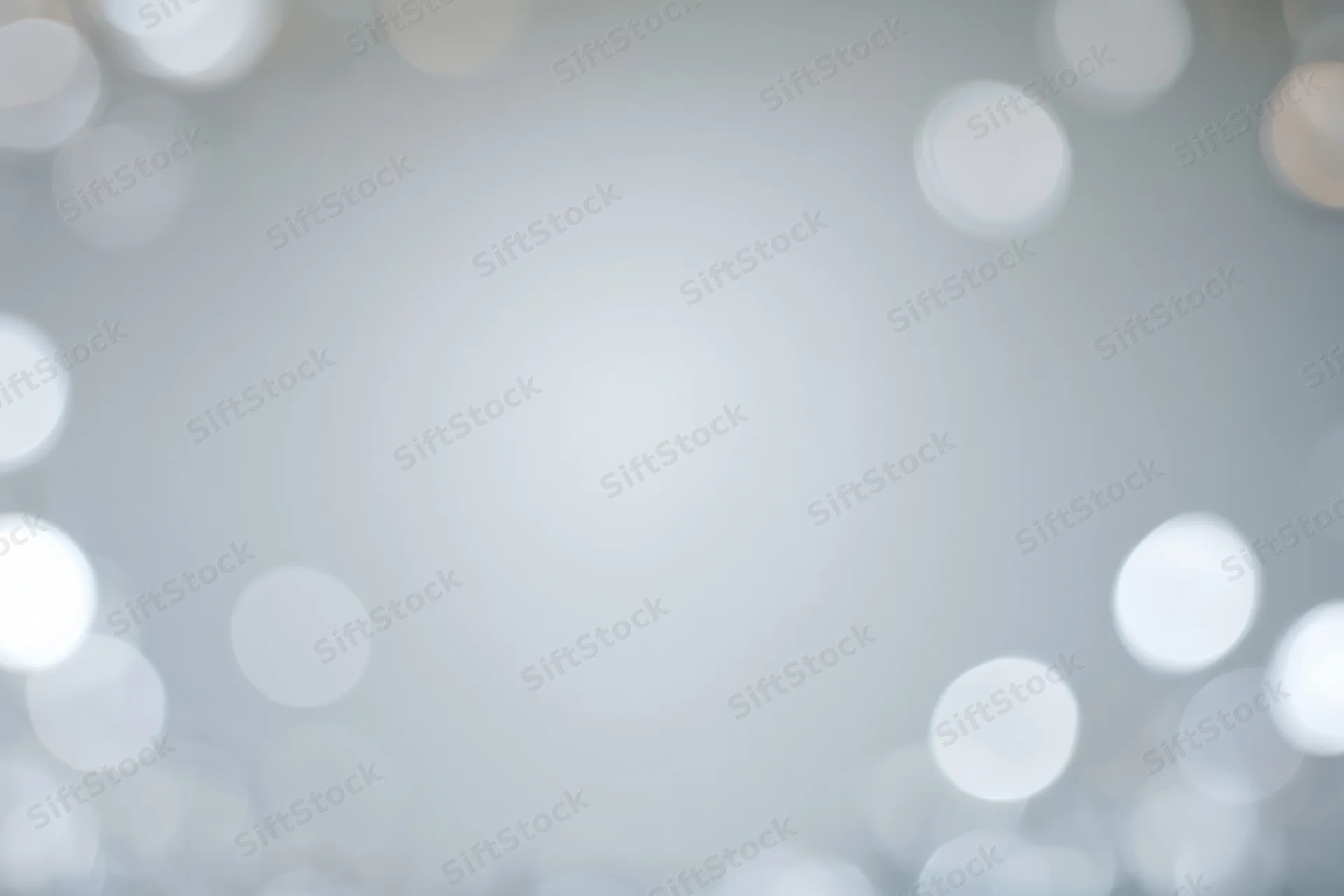 Soft out-of-focus bokeh circles floating against a smooth light gray background with copyspace in center