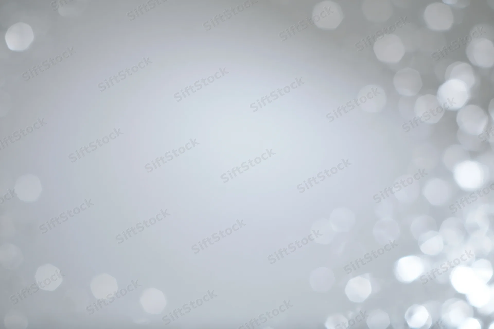 Soft white bokeh lights scattered across a smooth background with copyspace