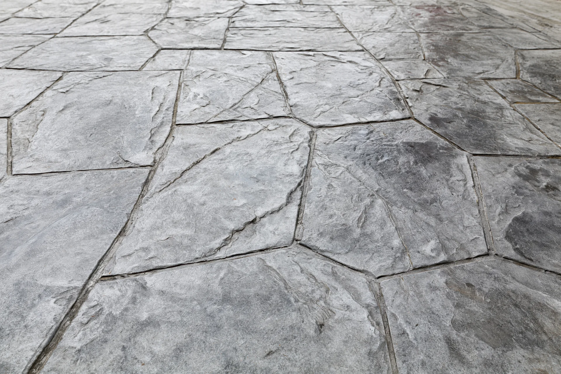 Stamped concrete pavement with irregular stone pattern for outdoor flooring