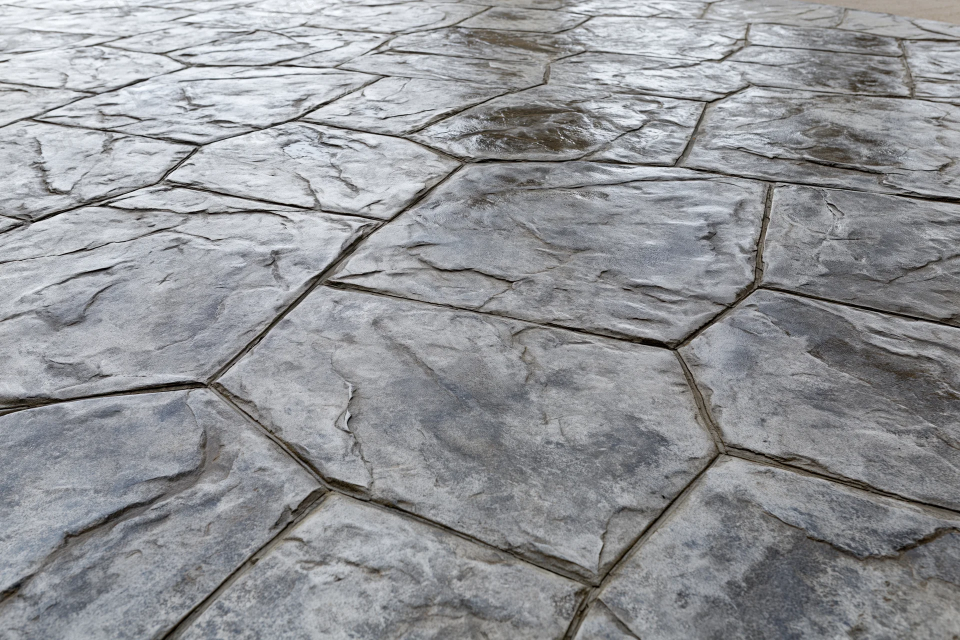 Stamped concrete surface with irregular stone pattern for outdoor flooring
