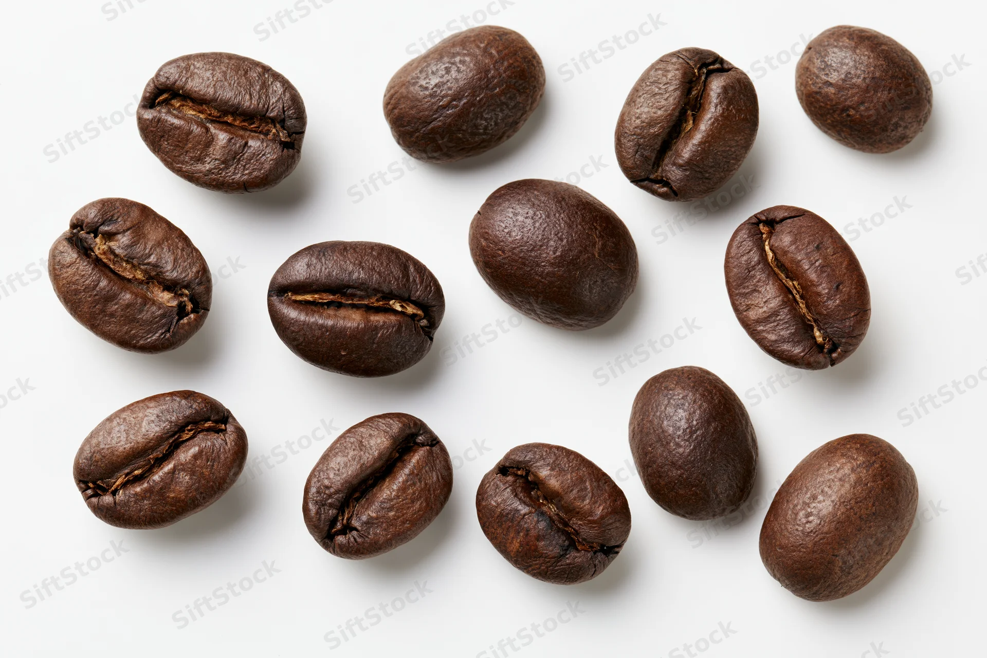 Roasted coffee beans scattered on a white background