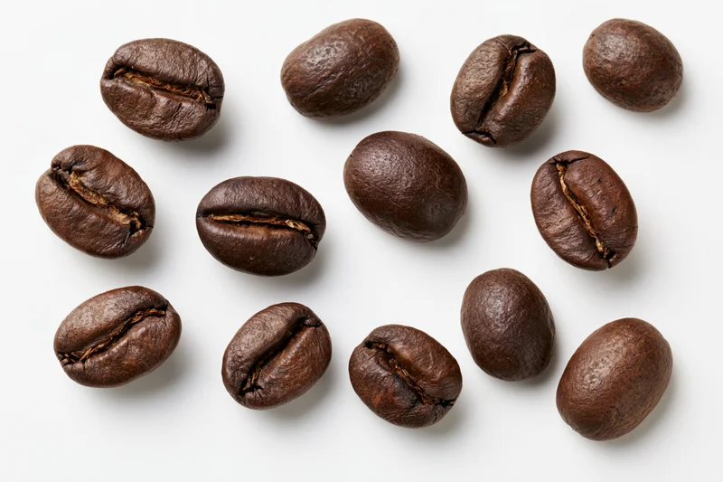 Roasted coffee beans scattered on a white background