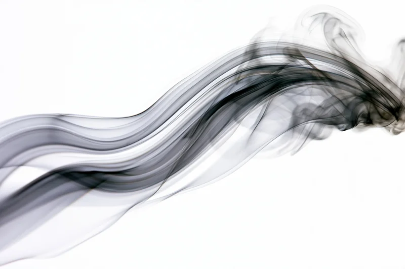 Dark smoke swirling across a white background
