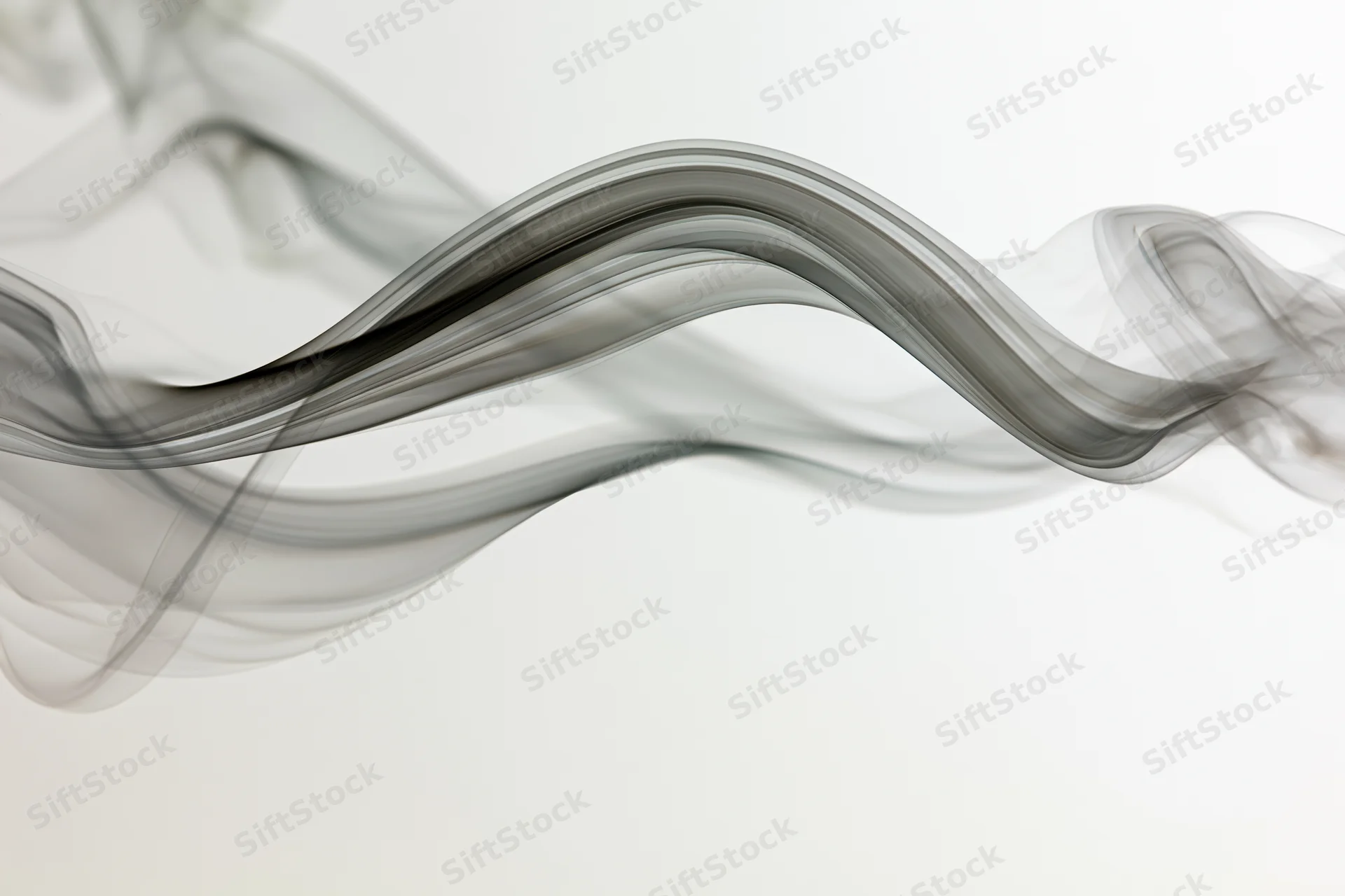 Flowing gray smoke drifting in curves across a white background