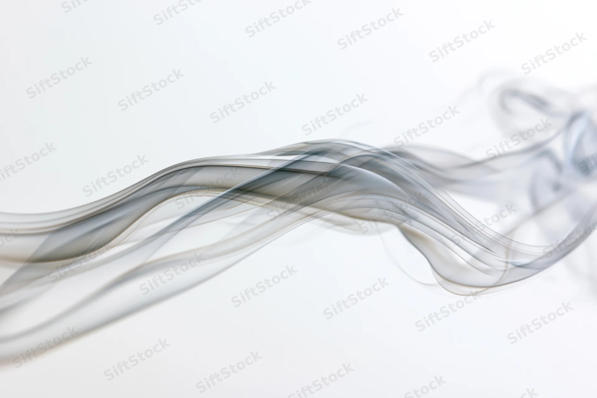 Thin gray smoke drifting in flowing curves across a white background