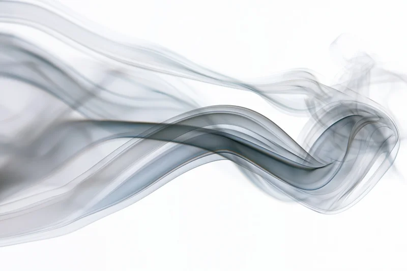Gray smoke drifting in flowing curves across a white background