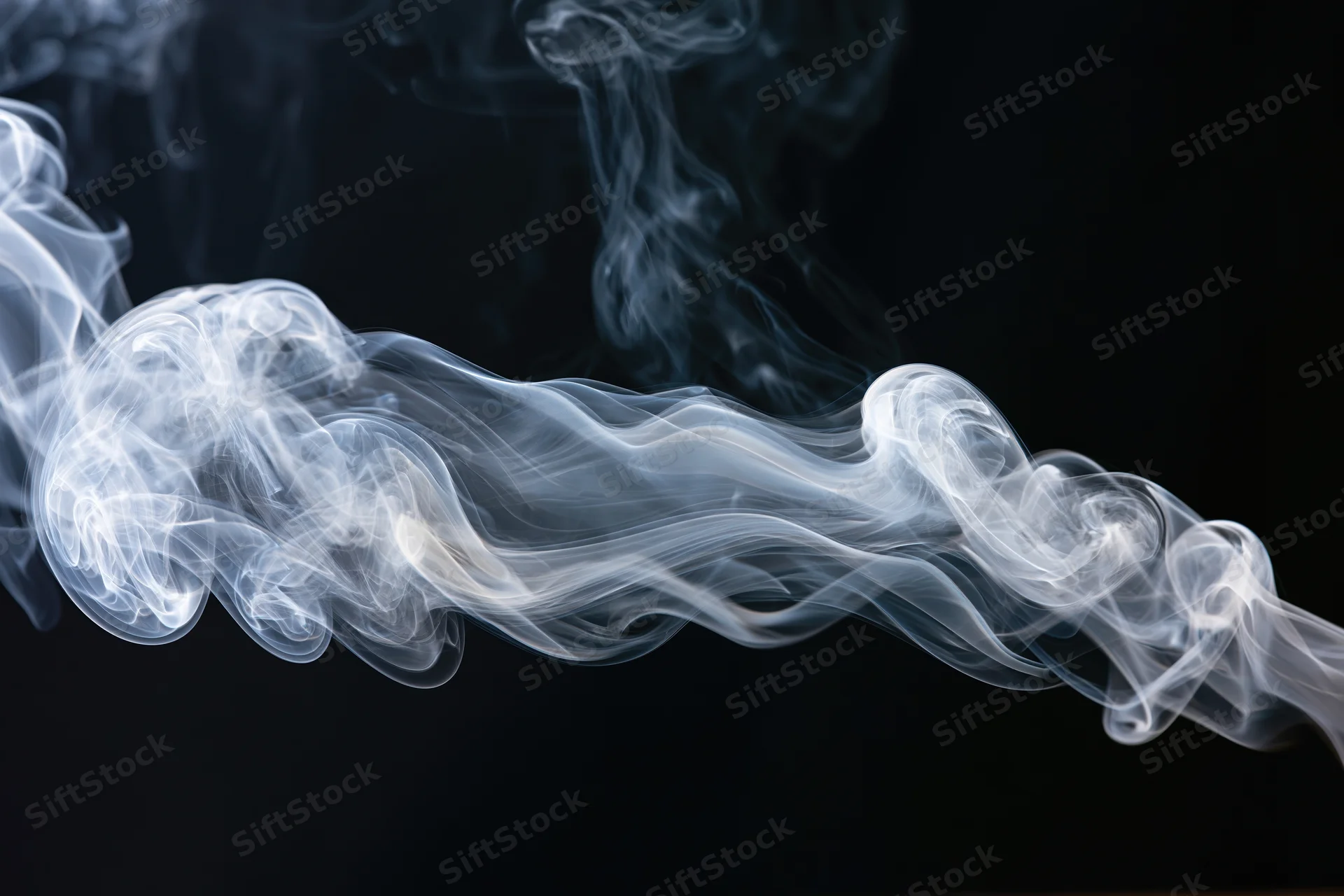 White smoke curling and dispersing in mid-air against a black background