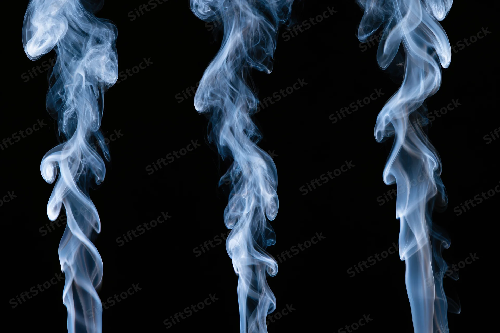 Three columns of rising white and pale blue smoke against a black background