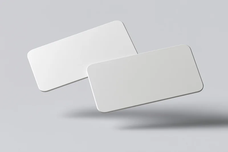 Two blank white business cards with rounded corners floating against a light gray background