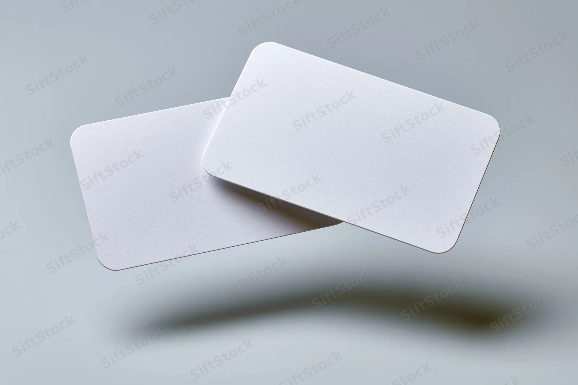 Two blank white business cards with rounded corners floating against a gray background