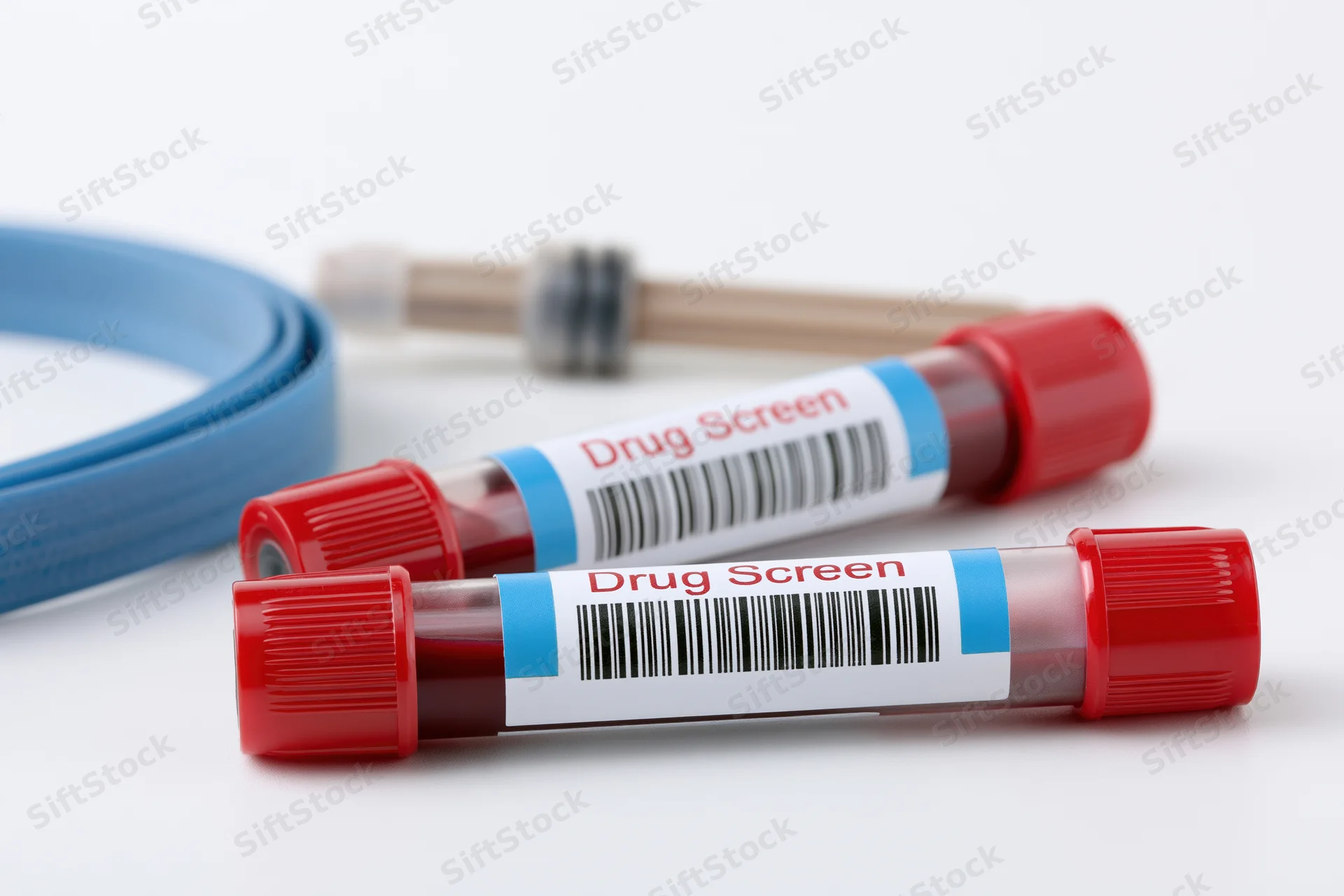 Two blood collection vials with red caps labeled drug screen on white surface