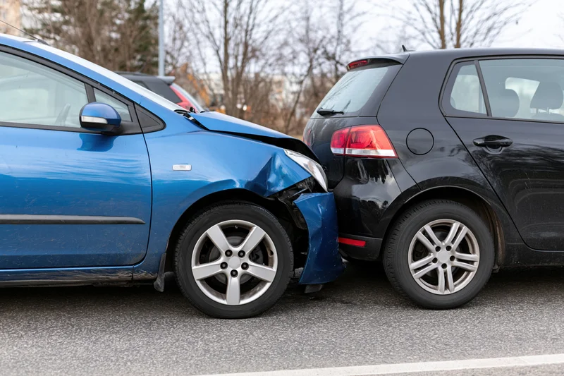 Two hatchbacks involved in a rear-end collision on a paved road