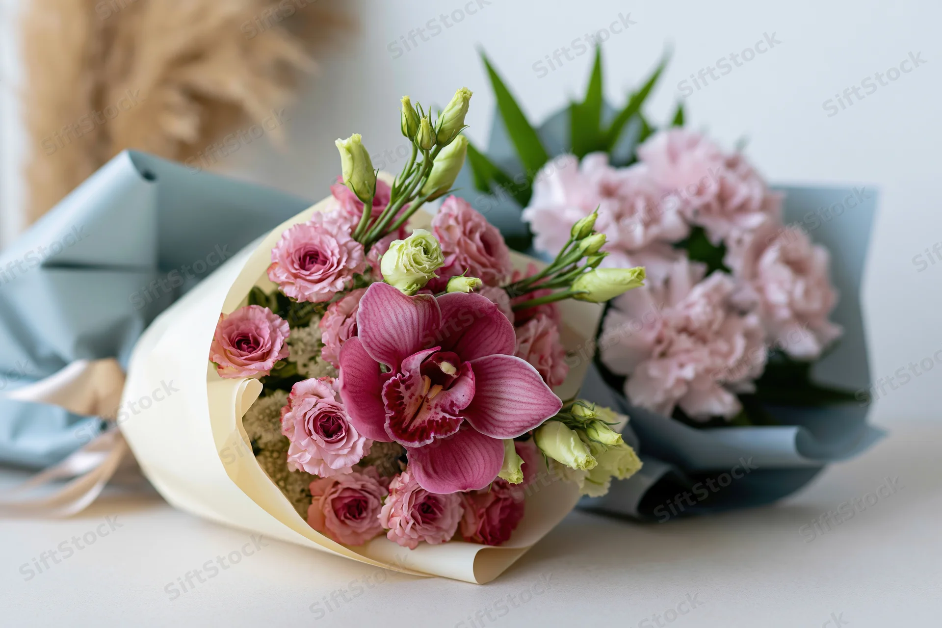 Two wrapped flower bouquets arranged side by side on a light surface