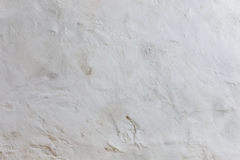 Weathered white concrete wall surface filling the frame