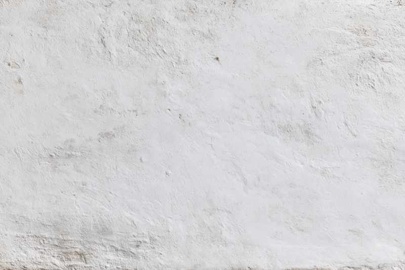 Weathered white concrete wall surface filling the frame